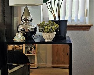 Mid-century modern black mirrored bedside tables with 2 drawers. There is a matching pair. Mid-century modern silver lamps that match as a pair. Bed not yet photographed yet nor other matching mirrored dressers that we do have available for sale. 