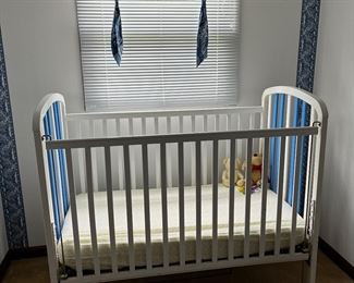 White crib and fabric window coverings