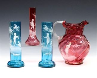 Four pieces of late 19th century Mary Gregory art glass.  Cranberry and Blue glass with white enameled decoration of playing  children.  Includes a pitcher, a pair of vases and a bud vase.  Some surface wear and losses to decoration, tiny flakes at rims.  Up to 8 3/4" high.