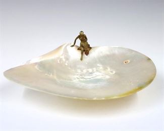 A turn of the century Mother of Pearl caviar dish.  Art Nouveau style with Gilt Bronze figure and foot.  Minor wear to shell and patina, glue reside at underside.  8" long. 

