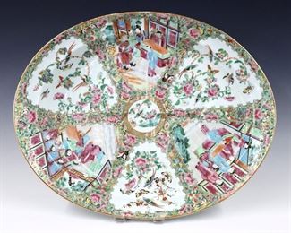 A Chinese Rose Medallion porcelain carving platter.  Oval form with angled well at one side, features polychrome vignette panels depicting alternating floral and Court scenes with Gilded detail.  Unmarked.  Minor wear to decoration, a few small flakes to rim.  18 3/4" long.  