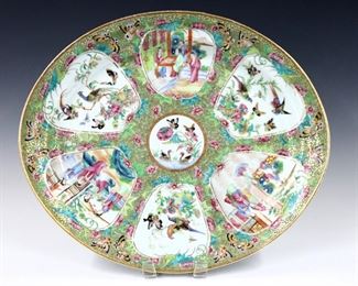 A Chinese Rose Medallion porcelain platter.  Oval form with polychrome vignette panels depicting alternating floral and Court scenes with Gilded detail.  Unmarked.  Minor wear to decoration, small flake to rim.  17" long.  
