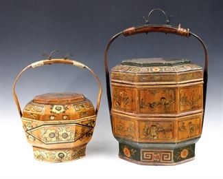 Two early 20th century Chinese Wedding Baskets with hand-painted decoration.  Octagonal Softwood boxes with rattan strap handles, one with two tiers and polychrome decoration, the other with a single tier and Gilded detail.  Some wear and minor damage.  Up to 12 1/2" diameter and 19" high.  
