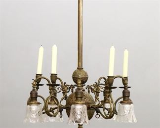A late 19th century American Victorian Period gas & electric chandelier.  Brass with ten scrolled arms on a embossed central column with pierced detail and ruffled glass shades.