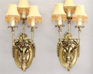 A pair of early 20th century Louis XVI style wall sconces.  Brass constuction with three upper and one lower arm on each with wreath detail.  Polished and re-wired.  Each 11" wide x 28" high overall.  
