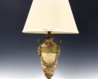 An early 20th century French Louis XVI style table lamp.  Marble and Gilt Bronze stem with Neoclassical frieze, two Bacchus mask handles and cast foot on a circular Marble base.  Re-wired, some flakes to marble and wear to patina, modern shade as-is.  29" high overall.  
