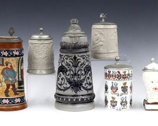 Five 19th and 20th century German beer steins.  Various Pewter lids and shaped thumb pieces over ceramic mugs.  Salt glaze and polychrome decoration by makers including Hauber & Reuther and Albert Stahl & Co.  MInor wear overall.  6 1/4" to 11 1/2" high.  
