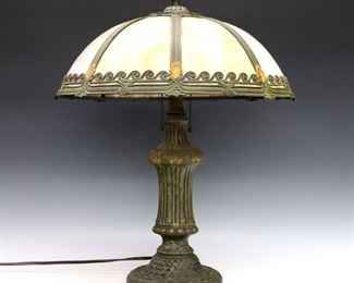 An early 20th century American bent panel table lamp.  Cast filigree shade with Amber Slag Glass panels on a stylized cast base and circular foot with polychrome painted finish.  Original finish with wear and loss to paint, glass panels with some surface wear.  22" high. 
