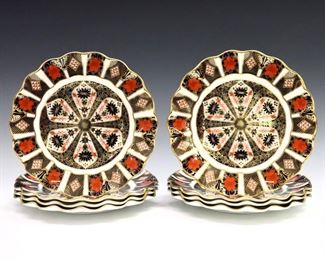 Eight 20th century Royal Crown Derby "Old Imari" pattern fine bone china scalloped dessert plates.  Printed marks in Red with "1128" and "LII".  Very slight surface wear, one plate with flake at underside of rim, printed marks scratched through.  8 1/2" diameter.  