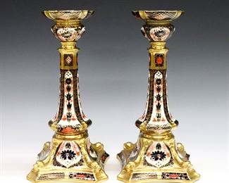 A pair of 20th century Royal Crown Derby "Old Imari" pattern fine bone china candlesticks.  Printed marks in Red with "1128" and "LII".  One bobeche expertly repaired, very slight surface wear.  Each 10" high.  
