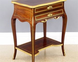 A turn of the century French Louis XV Style ladies work table.  Mahogany construction with Gilded Bronze mounts and moldings with inlaid Brass detail, features a shaped top over two dovetailed drawers lined in Birdseye Maple, on tall cabriole legs with a shaped medial shelf.  Polished older finish with minor wear.  22 x 15 1/2 x 29 1/2" high overall. 
