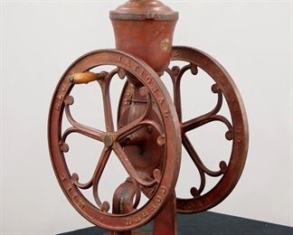 Lot 203: A turn of the century Elgin general store coffee grinder.  Cast Iron double grinder with upper hopper.  Old painted finish with wear, replaced eagle finial, lacks lower drawer.  30 1/2" high.  