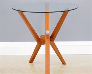A 1980's occasional table entitled "Nick's Trivet Table" by Ali Tayar, Turkish/American born 1959.  Teak construction with brushed aluminum fittings and a circular glass top.  Original finish, slight wear.  30" diameter x 30" high overall. 
