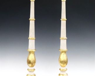 A pair of 18th century Italian wood altar sticks.  Turned Baluster stems with carved detail on a shaped base with three round feet.  White painted finish with Gilded detail.  Each 33" high.  