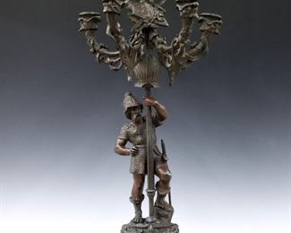 A turn of the century Spelter figural candelabrum.  Six light design with Gilded finial and four scrolled arms over a reeded stem with figure of a knight on a cast base with claw feet.  