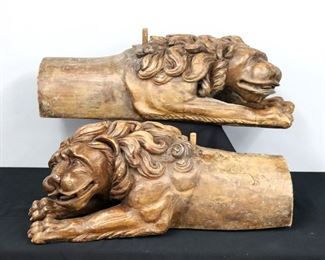 A pair of 19th century ship trailboard figures of Lions.  Carved wood construction depicting lounging lions with hollowed interiors to rest on a ship's trailboards flanking the stern.  Original finish with wear, shrinkage and minor damage, mounted to caster wheels.  Each 35 x 12 x 13" high overall.  ESTIMATE $800-1,200