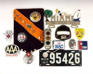 A collection of twenty-nine vintage automobilia pieces.  Includes nine car club badges, sixteen pins, a Stadco "Life Saver" signal, a Buick tail light lens, a Miami vanity plate, and a Michigan license plate.  Some wear and minor damage.  Up to 12" long.  ESTIMATE $200-300