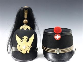 Two 19th and early 20th century military hats.  Each constructed of felt and leather, includes an American Indian Wars helmet with raised horsehair plume and cast eagle plate by Horstmanm Bros & Co., and a Swiss shako with leather chin strap, Red painted cross and pompom.  Helmet marked "Horstmanm Bros & Co., Philadelphia" at interior ring, shako with "Schweizerische Uniformen Fabrik, Bern-Zurich" label at interior. 