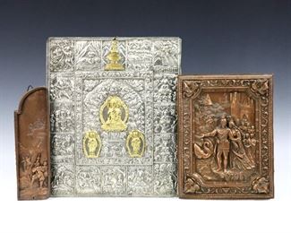 Three early 20th century repousse wall plaques.  Includes a Nepalese silver metal and Brass plaque depicting the travels of Buddha, and two electrotype Copper plaques depicting a scene from "Knight of the Swan", and villagers at a castle turret.  