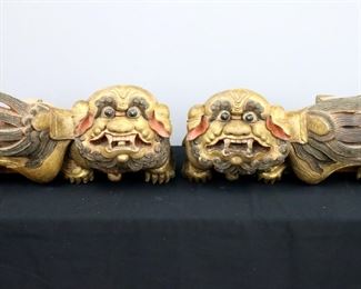 A pair of Chinese wooden architectural Foo Dogs.  Carved wood construction with two mounting inserts, polychrome painted finish and Gilded detail. 