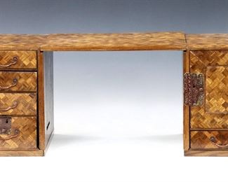 A turn of the century Japanese parquetry traveling desk.  Three piece mixed wood construction with engraved metal mounts, features a removable writing surface supported by handled bases fitted with four drawers on the left, and a cabinet with three drawers on the right. 