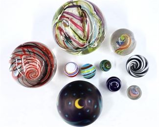 Ten vintage Art Glass marbles and paperweights.  Includes a 1987 Lundberg Studio "Night Sky" paperweight, a paperweight by Peter Patterson, and eight marbles of various sizes and designs.  Patterson paperweight with original sticker, Lundberg Studio paperweight signed and dated.  