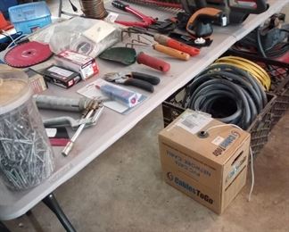 Garage is full of tools, sports equipment, garden and lawn equipment, camping gear.