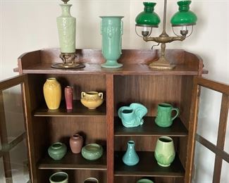Interior of Grand Rapids Bookcase and Chair Company "Lifetime" bookcase in original finish, showing Rookwood Pottery, Peters and Reed Pottery, Weller Pottery, Redwing Pottery, and a lovely old student lamp.