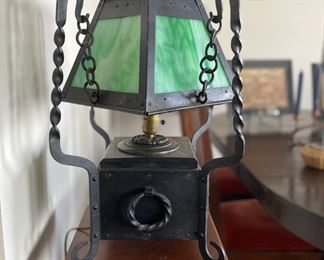 Arts and Crafts table lamp, original twisted iron base and chain supporting a green slag glass shade.  15" wide by 15" wide, 19" tall. 