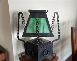 Arts and Crafts table lamp, original twisted iron base and chain supporting a green slag glass shade.  15" wide by 15" wide, 19" tall. 