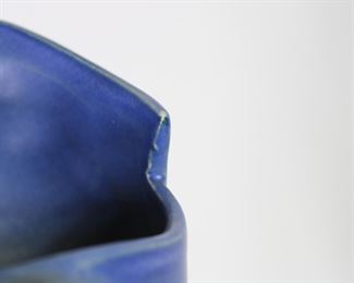 A detailed view of Roseville Pottery Freesia pitcher showing mold imperfections on rim