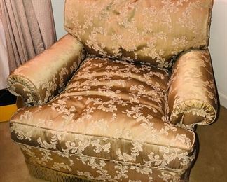 One of a pair of armchairs with down/feather cushions & fringe at base (34”W, 36”D, 28” high at back) N.B. Upholstery is a tan color in person