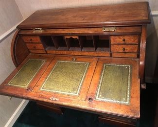 Interior of cylinder desk - with green leather inserts. Work surface slides in & out & center section has angled stand underneath (for slanted writing surface) 