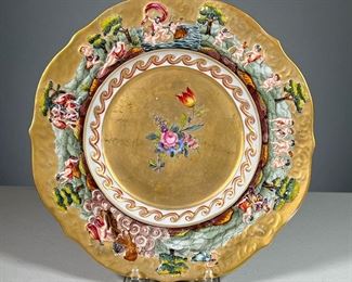 CAPODIMONTE PORCELAIN PLATE  |  Gilt plate with raised border depicting various nature scenes featuring cupids, chariots, and more.