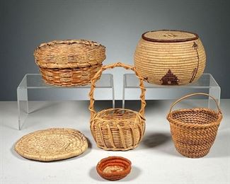 (6PC) WOVEN BASKETS  |  Including a small 19th century basket with bail handle, a lidded basket decorated with trees and houses (dia. 5.75 in.), a small placemat, a red woven basket of small size, and another lidded basket. 