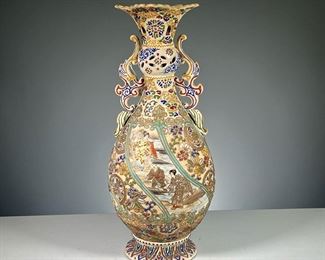 ANTIQUE SATSUMA VASE  |  Japanese vase colorfully and intricately decorated with floral devices and a scene of two women and a man by a river in reserve, with sculpted side handles and a reticulated neck. 