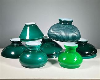 (10PC) GREEN GLASS LAMPSHADES  | Milk glass lampshades with dark green exteriors of various sizes and shapes, including one with a ribbed design