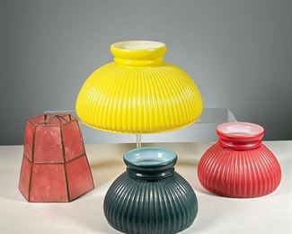 (4PC) COLORED GLASS LAMPSHADES  |  Including three domed and ribbed shades (one yellow, and two of smaller size in red and green), and a brass and pink glass panel lampshade. 