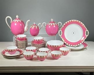 (33PC) PINK & GILT CHINA TEA SET  |  A fancy pink and white tea service with gilt highlights, including a teapot, 9 teacups and saucers, 8 small plates and 2 larger plates, 2 serving dishes with handles, a covered creamer, a sugar jar, and a bowl; with no apparent identifying marks. 