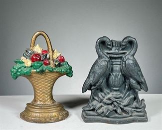 (2PC) ANTIQUE DOORSTOPS  |  Heavy iron door stoppers, included one in the form of a basket with fruits, the other in the form of two birds centering an urn. 