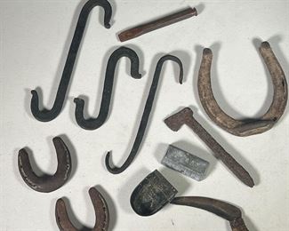 (11PC) COLLECTION: IRON & STEEL ITEMS  |  Includes: 3 horseshoes, 3 wrought iron hooks, a letter opener, old railroad tie reforged into decorative hatchet, small iron ingot stamped “Lyman”, and a steel chisel. 