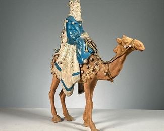 WISE MAN ON A CAMEL FIGURE  |  One of the 3 wise men dressed in blue carrying a gift atop a camel adorned with pearl beads and glitter. Dimensions: l. 11 x w. 3 x h. 14 in