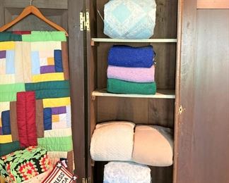 Antique armoire; quilts and blankets
