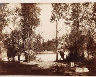 Rare circa 1880s cabinet card albumen photograph entitled "Scenery of the Yellowstone Park, The Teton Range, Snake River". The photograph shows a hunter striking a pose and leaning on his rifle while gazing across the Snake River. His guide and a pack mule are standing nearby.