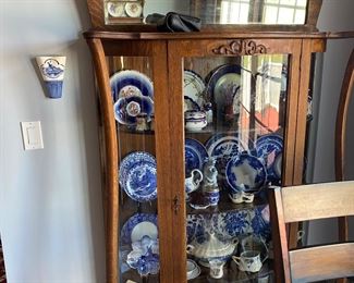 solid oak antique curved glass china cabinet filled with blue white china 