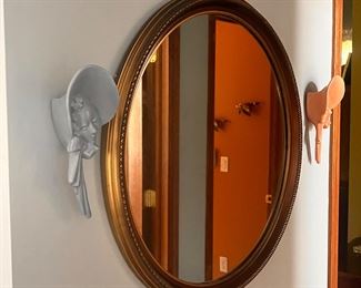 cute oval mirro flanked by yet more wall pockets 