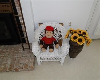Child's wicker chair, sunflower vase, and Curious George