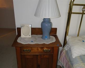 Oak nightstand with lamp and ceramic picture frame