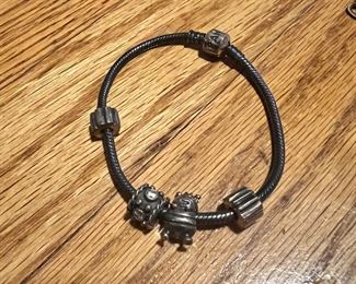 Pandora bracelet in sterling silver… features a rare “queen bee” charm with the gold crown.