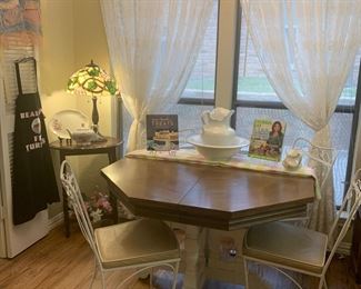 The kitchen table is 44" x 44" without its leaf. It has 4 white metal chairs.